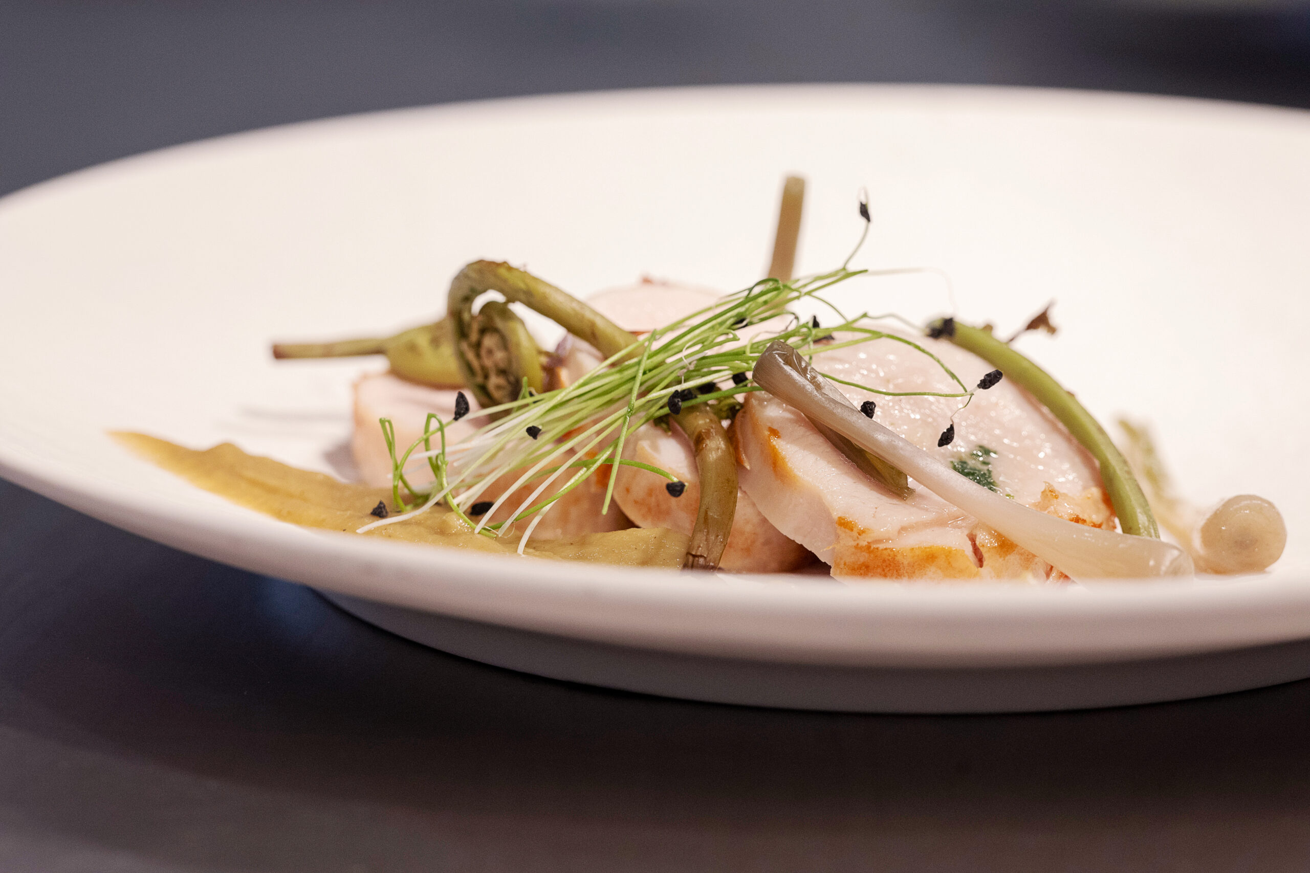 Sliced roast chicken with fiddlehead ferns and mushrooms